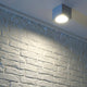 Big Theo Wall Out Wandleuchte eckig silbergrau ES111 max. 75W an einer Wand aus heller Ziegelstruktur.
