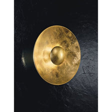 Aura Sol Gold wall and ceiling light Ø 90 cm on a black wall, elegant design with a gold finish.