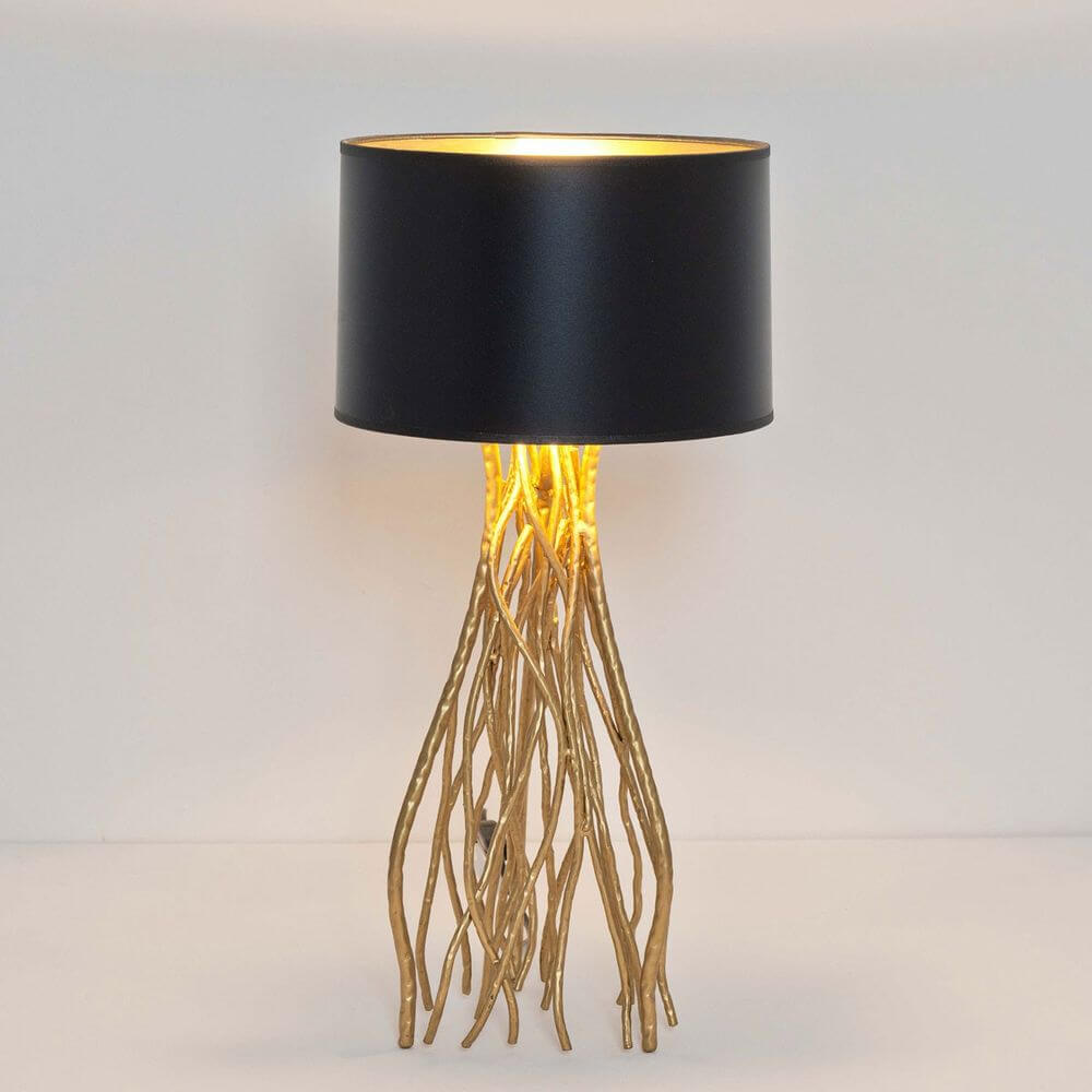 Tischleuchte Capri Mittel Metall Gold-Schwarz mit schwarzem Lampenschirm und goldenen Ästen als Basis.