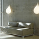 Drop-3S Wandleuchte 47cm Liquid-Light Weiß an einer stilvollen Wand über einem modernen Sofa.