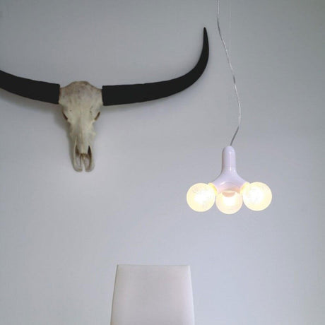 DNA Single-3 Lampada a sospensione in rame con tre sorgenti luminose su una parete in arredamento moderno.