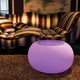 Moree Bubble Tisch oder Hocker mit lila LED-Beleuchtung und Gläsern in modernem Wohnraum.