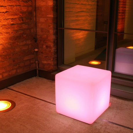 Pufa Moree Cube Outdoor z LED w różowym świetle, idealna do użytku na zewnątrz jako siedzisko lub dekoracja.