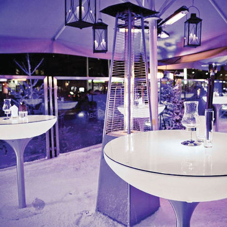 Moree Lounge Table Outdoor bartafel 105 cm in een elegante omgeving met lampen en verwarmingsstralers.
