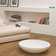Salon moderne avec table basse ronde et basse ainsi qu’un canapé confortable pour un habitat élégant.
