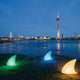 Moree LED Akku Dekoleuchte Shark mit Farbwechsel IP44 leuchtet in verschiedenen Farben am Wasser.