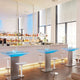 Moderne Bar mit beleuchteten Tischen und stilvollen Stühlen. Ideal für Events und Lounge-Ambiente.