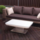 Moree Studio 45 Outdoor Tisch (S14d) auf einer Terrasse mit braunem Sofa und Gartenpflanzen.