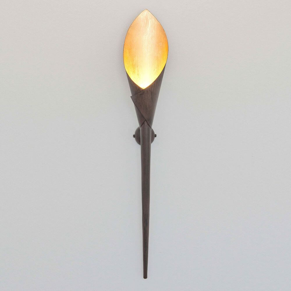Wandleuchte Fiaccola Grande Eisen Braun-Schwarz-Gold an einer Wand mit warmem Licht.