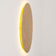 Wandleuchte Meteor Eisen Gold an der Wand, ovales Design mit warmem Lichtschein.