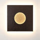 Wandleuchte Luna Quadrat Gross Eisen Braun-Schwarz-Gold auf einer Wand mit sanfter Beleuchtung.