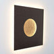 Wandleuchte Luna Quadrat Gross Eisen Braun-Schwarz-Gold mit goldenem Lichtkreis auf schwarzem Hintergrund.