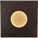 Wandleuchte Luna Quadrat Gross Eisen Braun-Schwarz-Gold mit runder, goldener Lichtquelle auf dunklem Hintergrund.