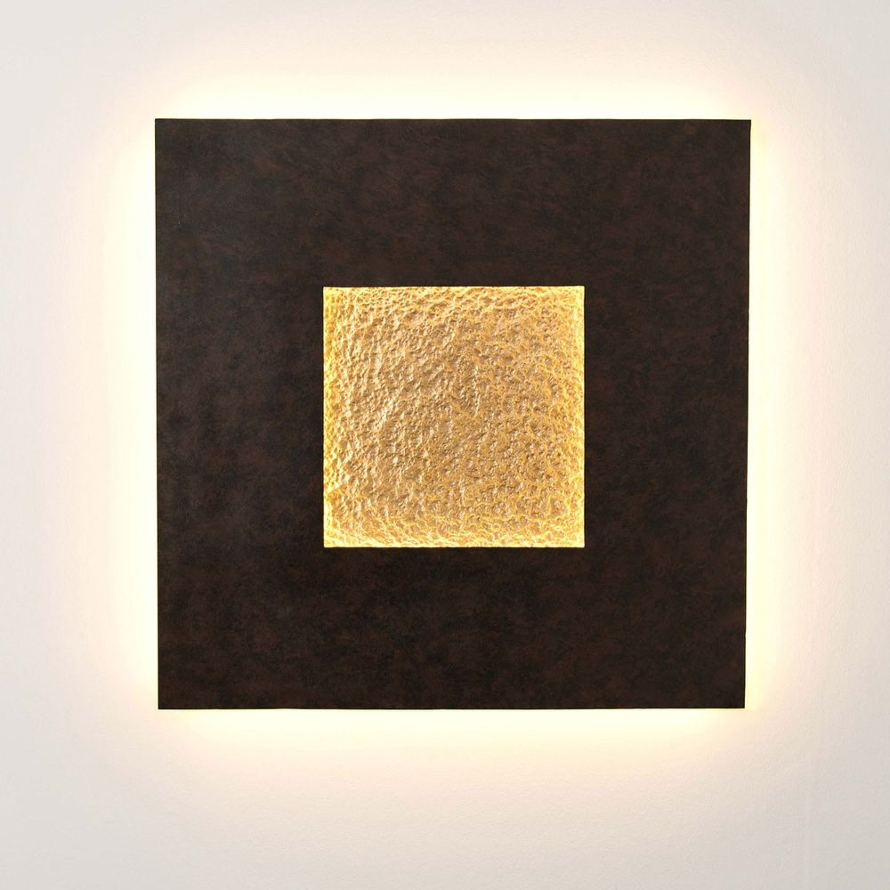 Wandleuchte Eclipse Gross Eisen Braun-Schwarz-Gold an Wand mit warmem Licht und goldener Detailfläche.