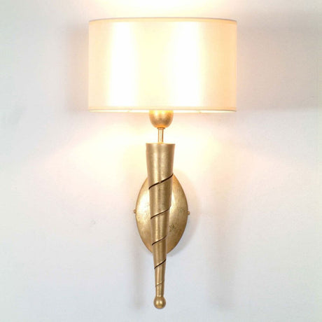 Aplique Innovazione de hierro dorado con diseño elegante en color dorado e iluminación acogedora.