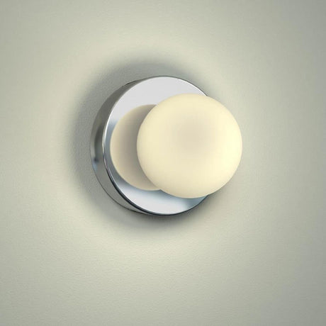 Azos mirror wall light Ø 10cm IP44 chrome, white mounted on a wall with soft illumination.
