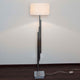 Stehleuchte Trimestre Metall verchromt Silber mit modernem Design und weißem Lampenschirm auf dunklem Boden.