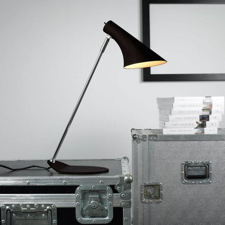 Klassische schwarze Tischleuchte Vanila auf einem Tisch mit Koffer, ideal für Wohn- und Arbeitsbereiche.