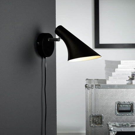 Vanila wall light in black mounted on a wall, modern design with a classic metal finish.