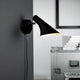 Vanila Wandleuchte Schwarz an einer Wand montiert, modernes Design mit klassischem Metallfinish.