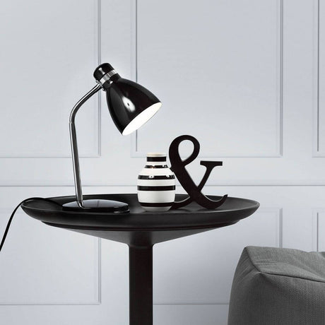 Lampe de table Cyclone noire sur une table moderne avec décoration.