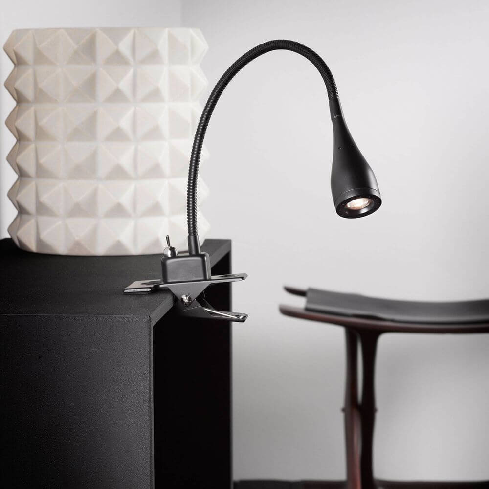 Mento LED Klemmleuchte Schwarz elegant auf einem Tisch montiert, ideales Licht für jeden Raum.