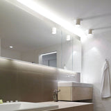 Moderne IP S4 Wandleuchte in Weiß über dem Waschbecken im stilvollen Badezimmer.