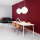 Abgerundete Pendelleuchte Norm12 XL Weiß im modernen Essbereich mit roter Wand und minimalistischen Möbeln.
