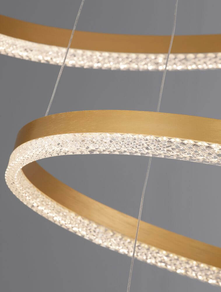 Adria LED Pendelleuchte 3-flammig Ø 80cm mit goldenen Ringen und glitzerndem Licht.