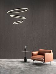 Adria LED suspension 3 lumières Ø 80 cm au-dessus d’un salon moderne avec un canapé élégant et une table d’appoint.