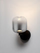Aelia LED Wandleuchte 3000K mit metallischer Halterung und rauchgrauem Glas für elegantes Interior.