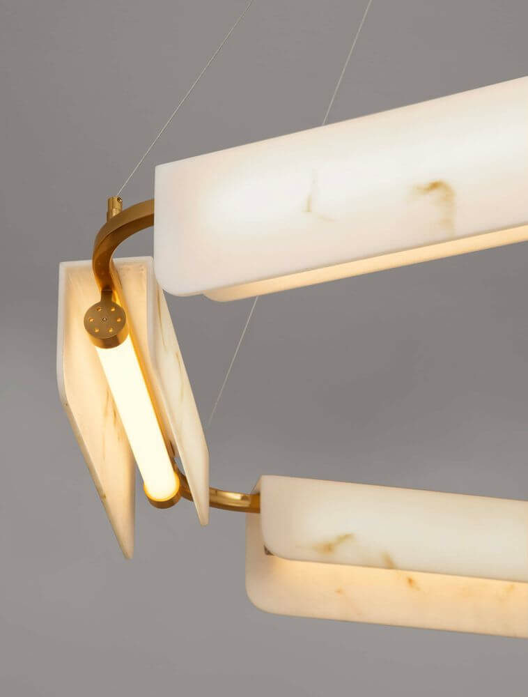 Aider Pendelleuchte 5-flammig Ø 93cm - Nahaufnahme weißer Marmor-Glasschirme mit warmem Leuchtrohr und goldfarbener Metallaufhängung