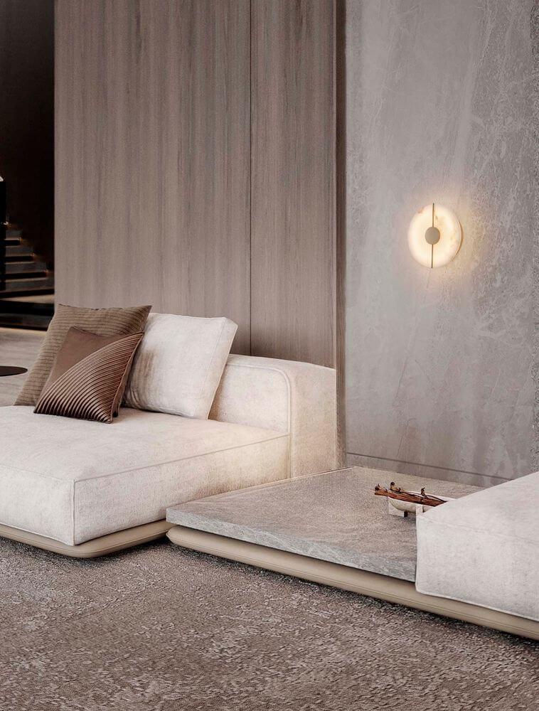 Aider Wandleuchte 3000K an Wohnzimmerwand in Goldfinish mit alabasterähnlichem Element und warmem LED-Licht