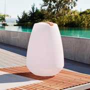 Lampe décorative LED à batterie Vessel 2 avec poignée en bois et contrôle par application au bord de la piscine sur une terrasse en bois.