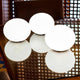 Drei Akku LED-Designleuchten Flatball in harmonischer Anordnung auf einem Tisch.