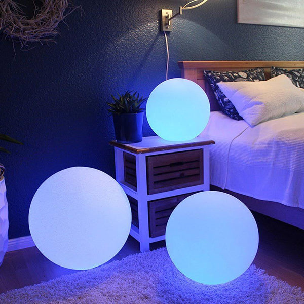 Rechargeable LED globe lamp Globe 50 cm with app control in a cozy bedroom with blue lights.