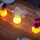 Akku LED-Tischvase Olio mit App-Steuerung auf Holztisch mit Blumendekoration und sanftem Licht.