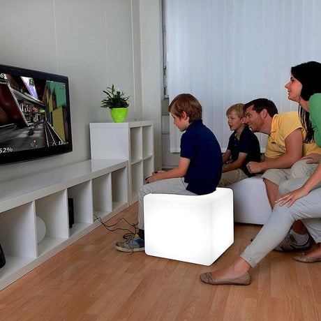 Cubo con batteria LED Cube 35 cm con controllo tramite app come moderno cubo seduta in un soggiorno con famiglia.