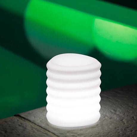 Lampada di design a lanterna sospendibile a batteria LED con controllo tramite app su un tavolo, con una luce soffusa.