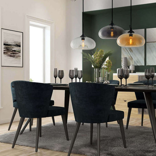 Elegantes Esszimmer mit stilvollen grünen Stühlen, modernen Pendelleuchten und einem eleganten Tisch.