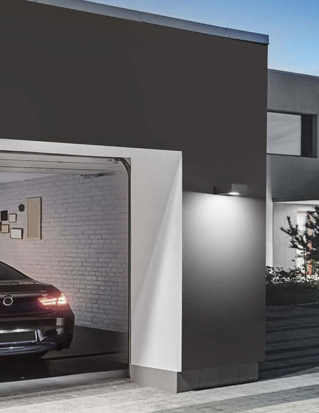 Apollo LED outdoor wall light 3000K dark grey IP54 on a modern house wall with garage.