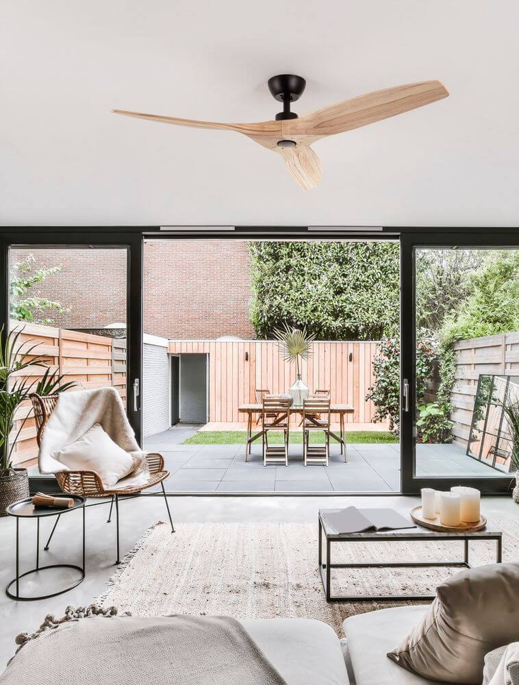 Arcadia Ventilator Ø 132cm im modernen Wohnraum mit Holzflügeln und mattschwarzem Aluminiumgehäuse.