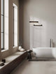 Arga LED Wandleuchte 45cm 3000K IP44 im modernen Badezimmer mit freistehender Badewanne.