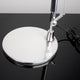 Detailaufnahme des Fußes der Artemide Tolomeo Micro Tischlampe mit glänzender Oberfläche und schwarz-weißem Hintergrund.