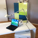 Moderne Tischleuchte Tolomeo Tavolo mit Laptop und Bücher auf einem weißen Schreibtisch in einem Büro.