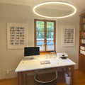 Helles, modernes Homeoffice mit minimalistischem Schreibtisch und runder Pendelleuchte.