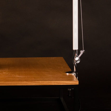 Artemide Tolomeo Tischklemme Alu an einem Holzschreibtisch, geeignet für verschiedene Tischplattenstärken.