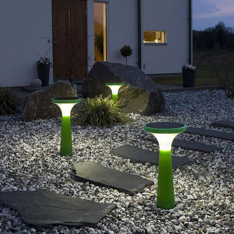 LED Solar Dekoleuchte Assisi Aton 45cm Grün im Garten mit effektiver Beleuchtung auf Steinen und Pflanzen.