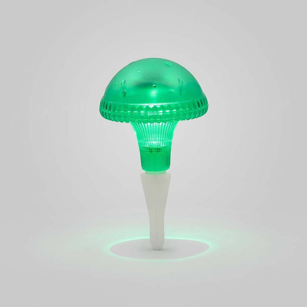 Lámpara LED solar en forma de hongo Assisi verde en un brillante verde sobre un fondo claro.