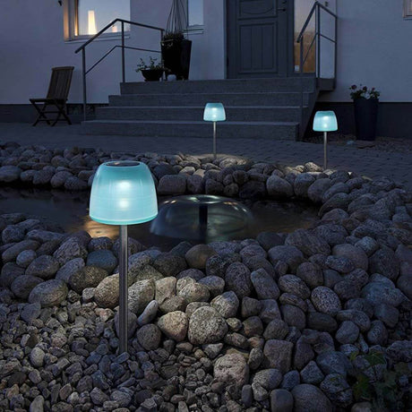 LED Solarspieß Assisi Qualle 56cm Türkises Acrylglas im Garten zwischen Steinen und Wasserbecken.